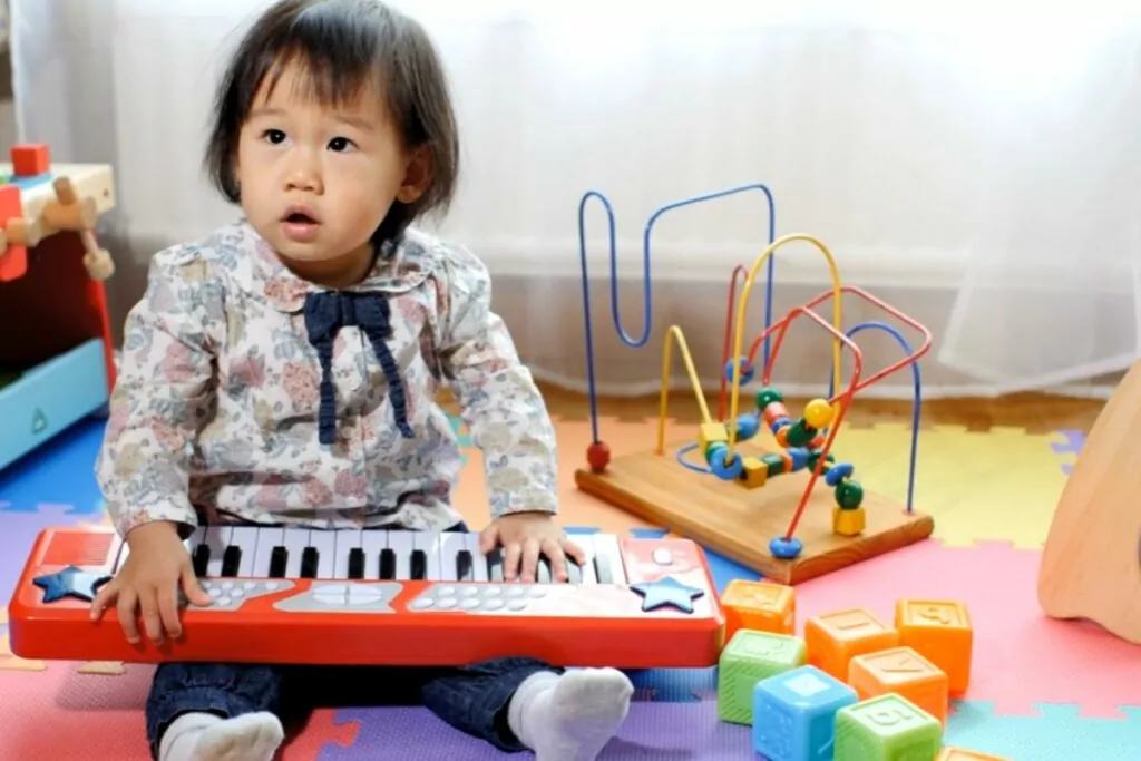 a small child playing with a keyboard piano
