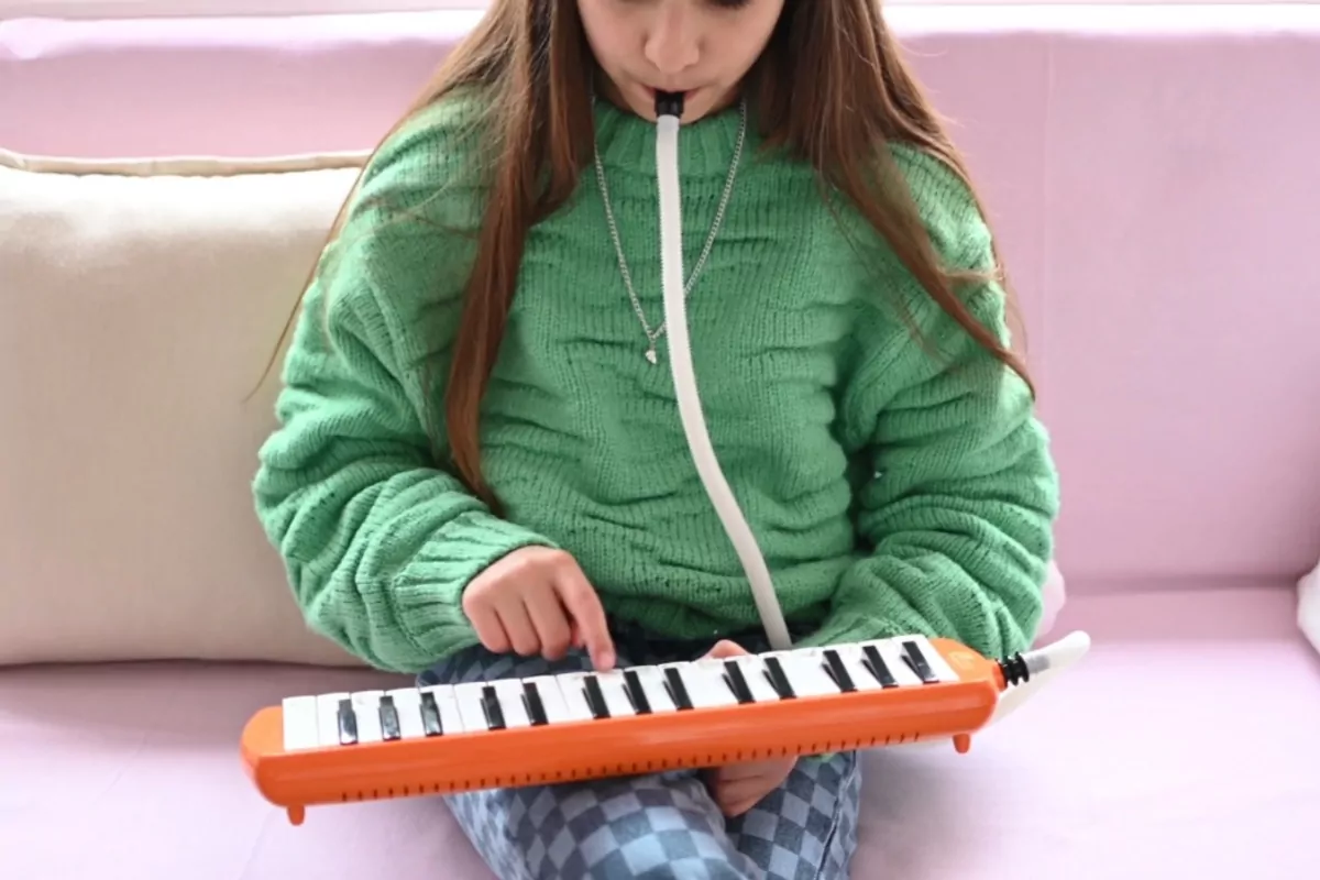 a girl playing with a melodica