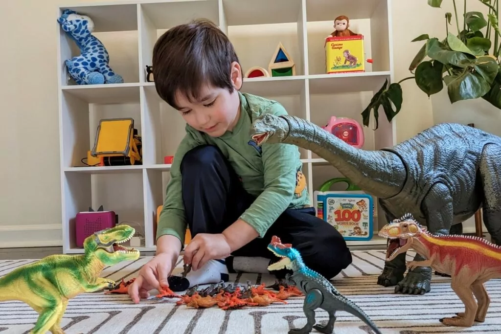 autistic boy playing with dinosaurs