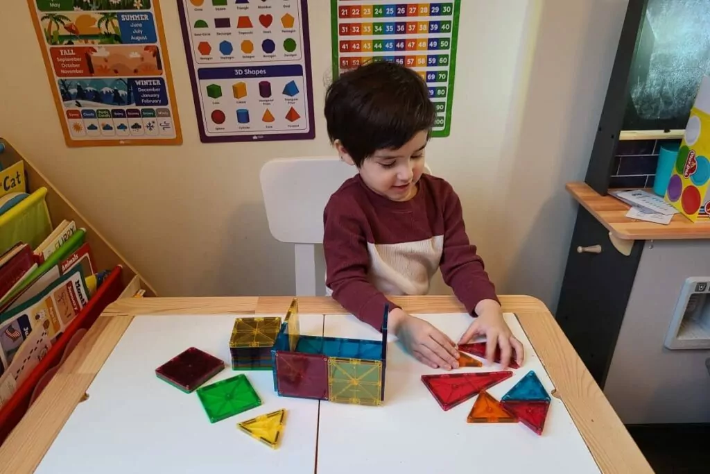 autistic child playing with magna-tiles