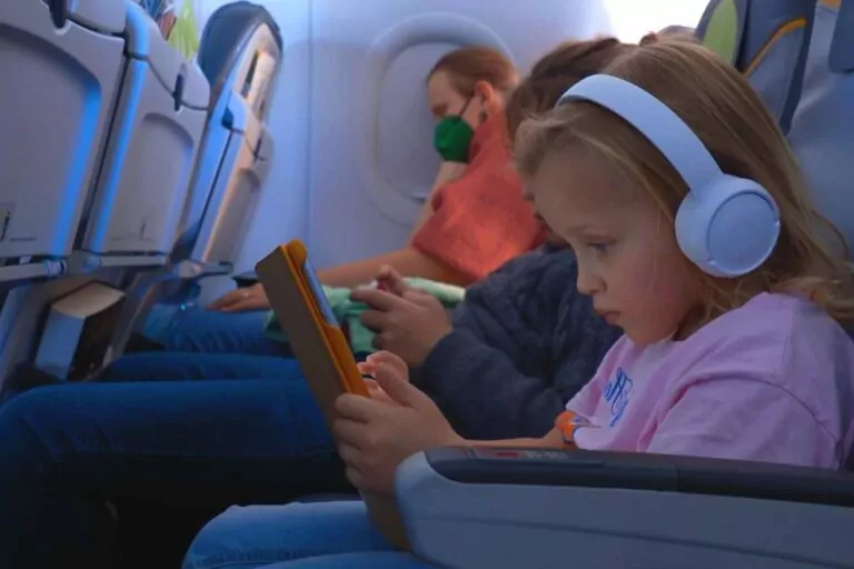 Girl using a tablet while traveling on an airplane